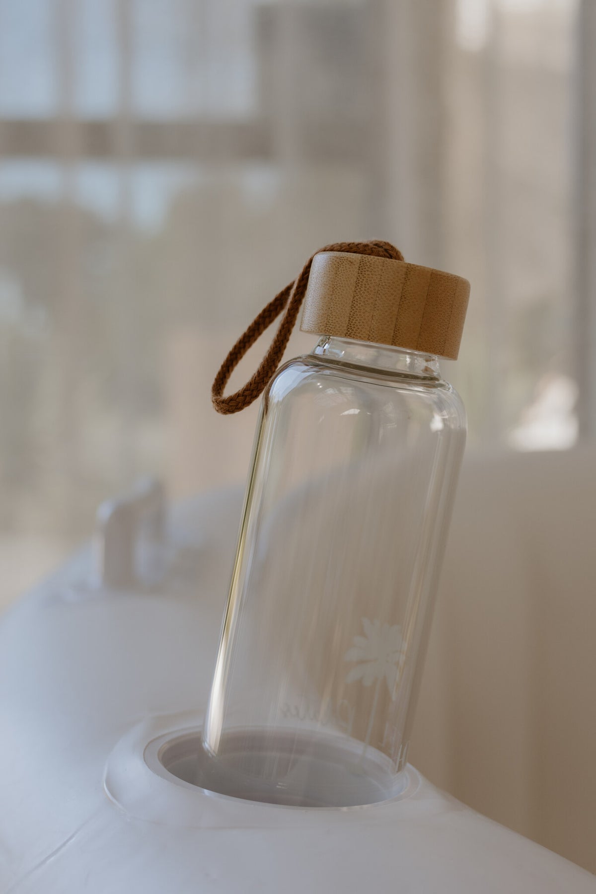 Glass water bottle resting on the edge of the hire birth pool to stay hydrated during labour
