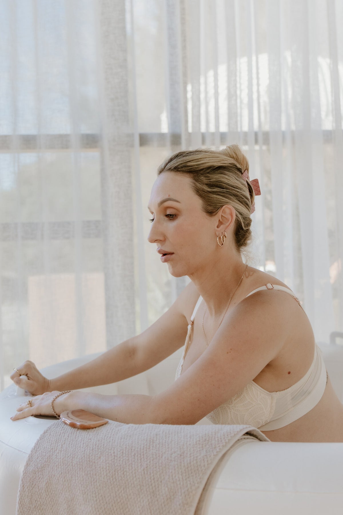 Labouring woman leaning on the padded edge of a Natural Cream hire birth pool at home