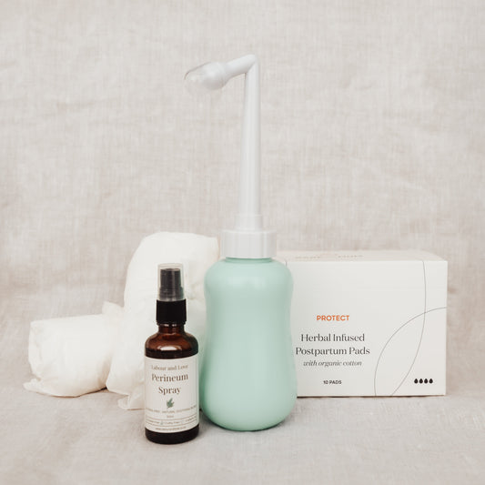 Perineum spray, Organic Cotton Postpartum Undies, and Organic Postpartum Pads, and Peri Bottle on a neutral background