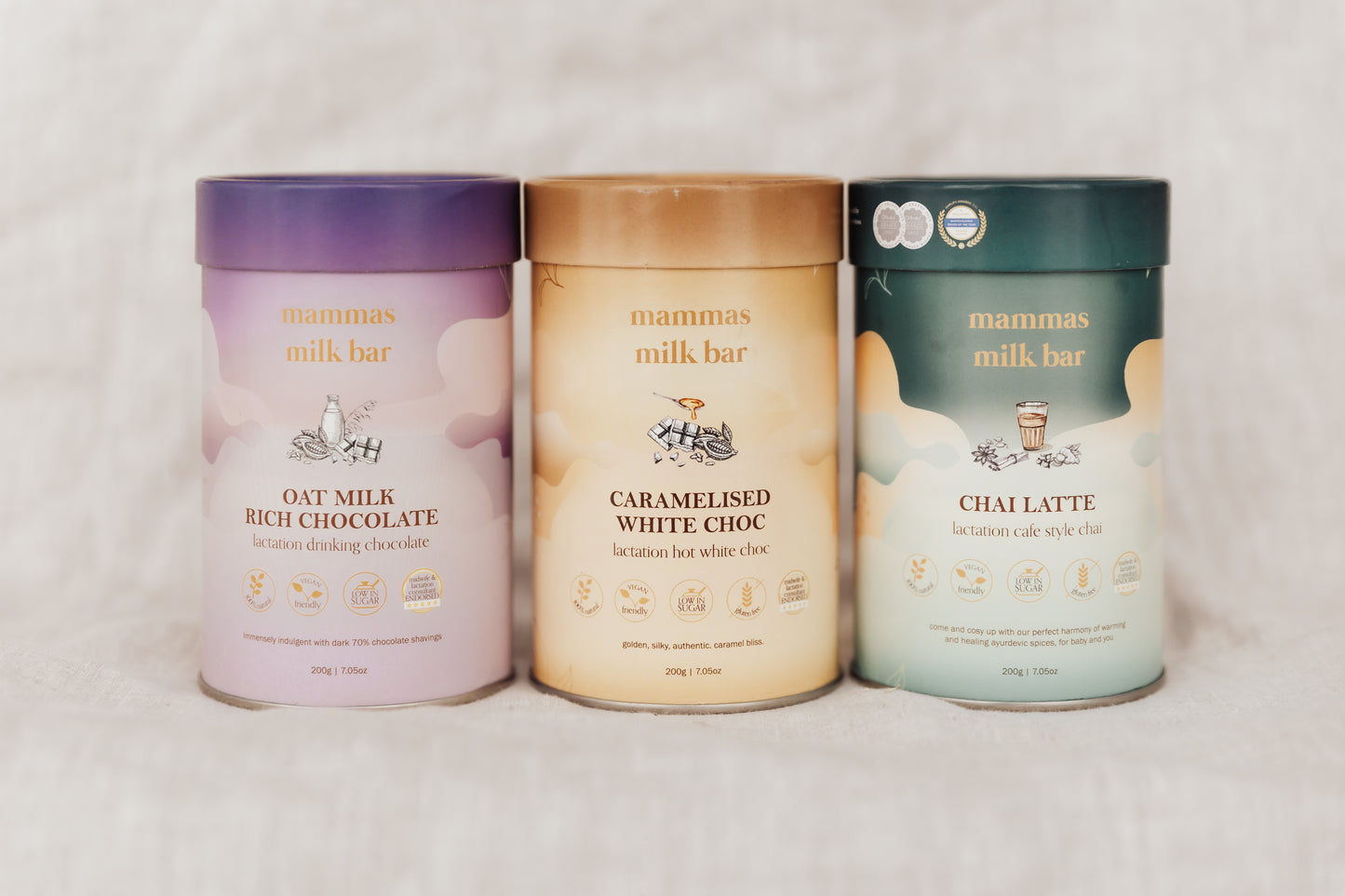 Three containers of Mamma's Milk Bar with different flavors on a light background