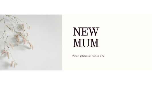 Soft editorial flat lay of wrapped new mum gift box items, kraft paper, sage ribbon and dried botanicals on linen