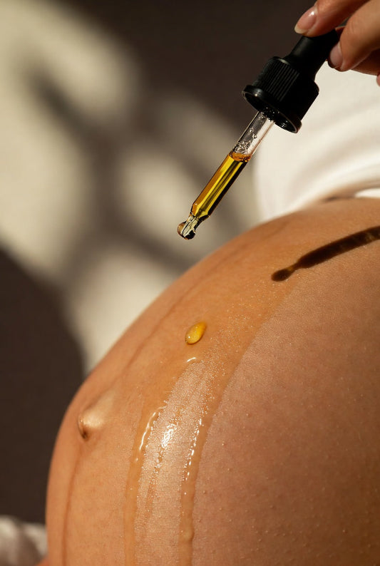 Pregnant woman applying Labour and Love organic belly oil to her bump — using belly oil in pregnancy