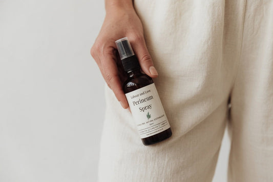 Hand holding a bottle of Labour and Love perineum relief spray — natural support for perineal healing after birth