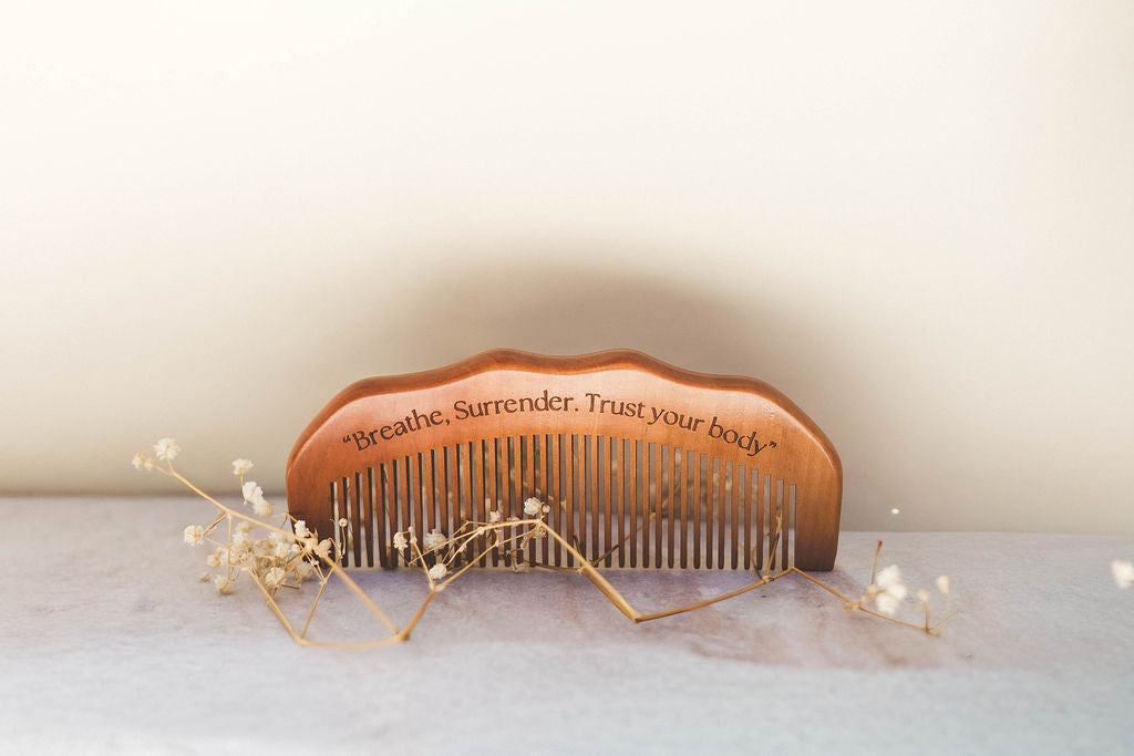Wooden birth comb held in the palm to press acupressure points during contractions