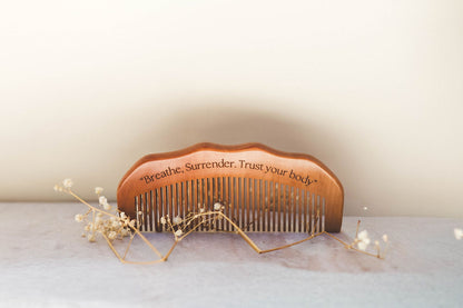 Wooden birth comb held in the palm to press acupressure points during contractions