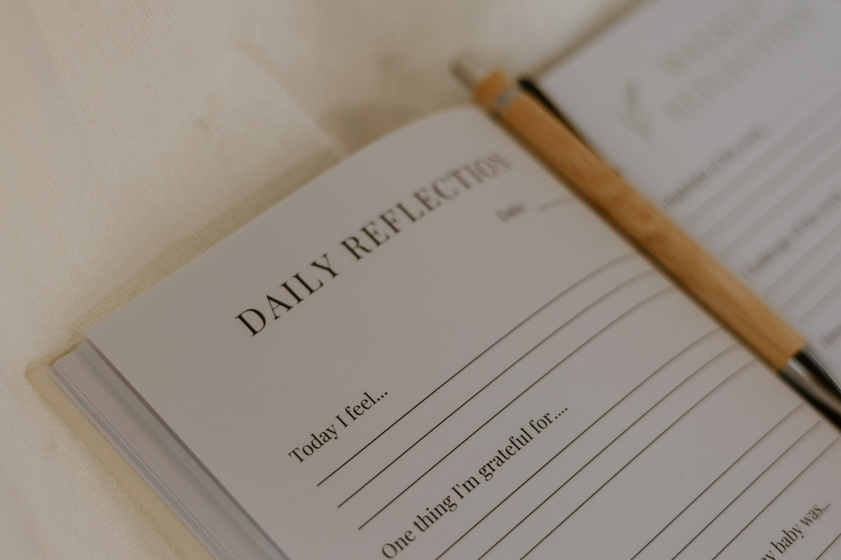 Daily reflection page of the postpartum journal with prompts for how you feel and what you're grateful for