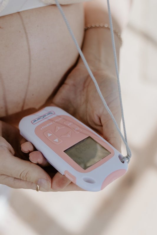 Hands holding the TensCare Perfect mama+ labour TENS unit, drug-free contraction pain relief for hire