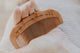 Wooden birth comb engraved with an affirmation, held in an open palm, natural labour pain relief tool