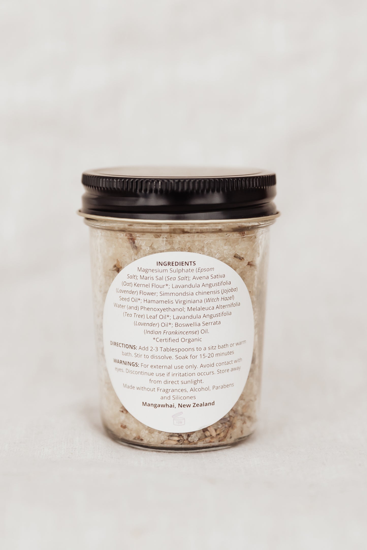Jar of bath salts with a label on a white background