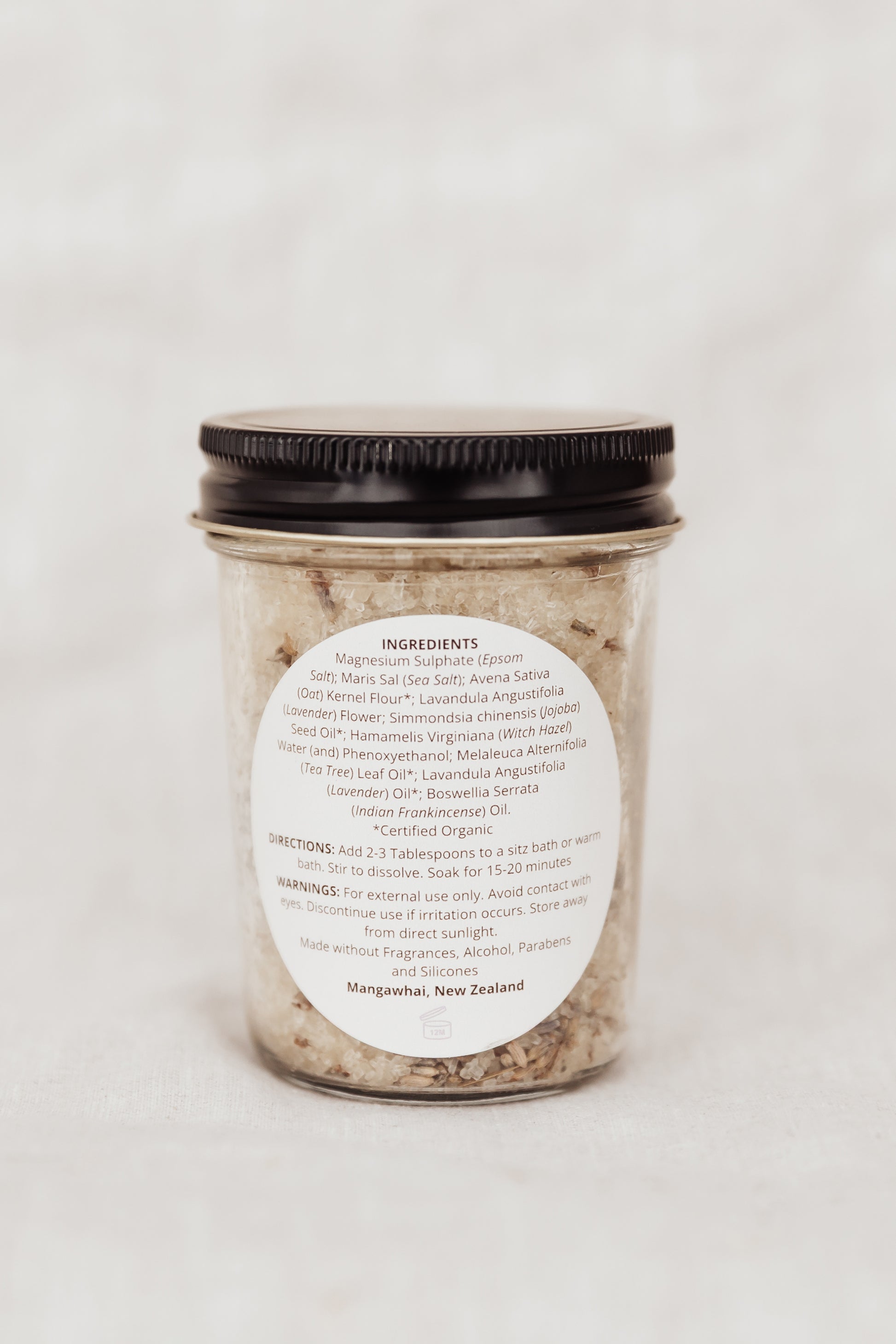 Jar of bath salts with a label on a white background