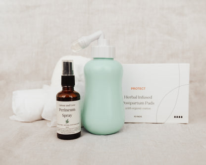 Four products including a peri bottle, perineum relief spray, organic cotton disposable postpartum undies and box of organic postpartum pads on a neutral background. 