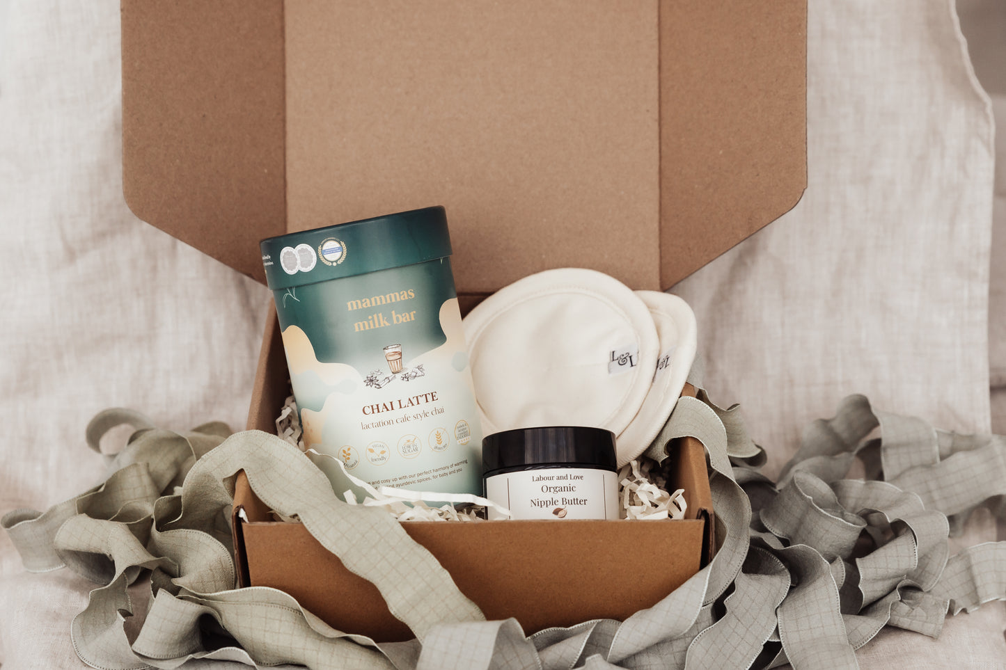 Gift set with breastfeeding products in a box on a soft fabric background