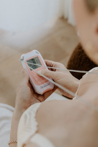Woman adjusting the settings on a hired TensCare Perfect mama+ labour TENS machine